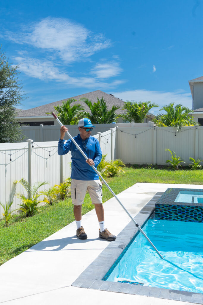 M&G Pool Services technician cleaning a residential pool in Central Florida